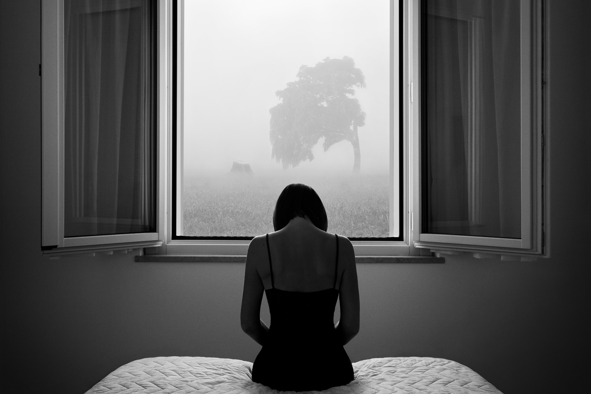 Award Winning black and white fine art photography, a lonely girl in front of the window. Fine art self-portrait