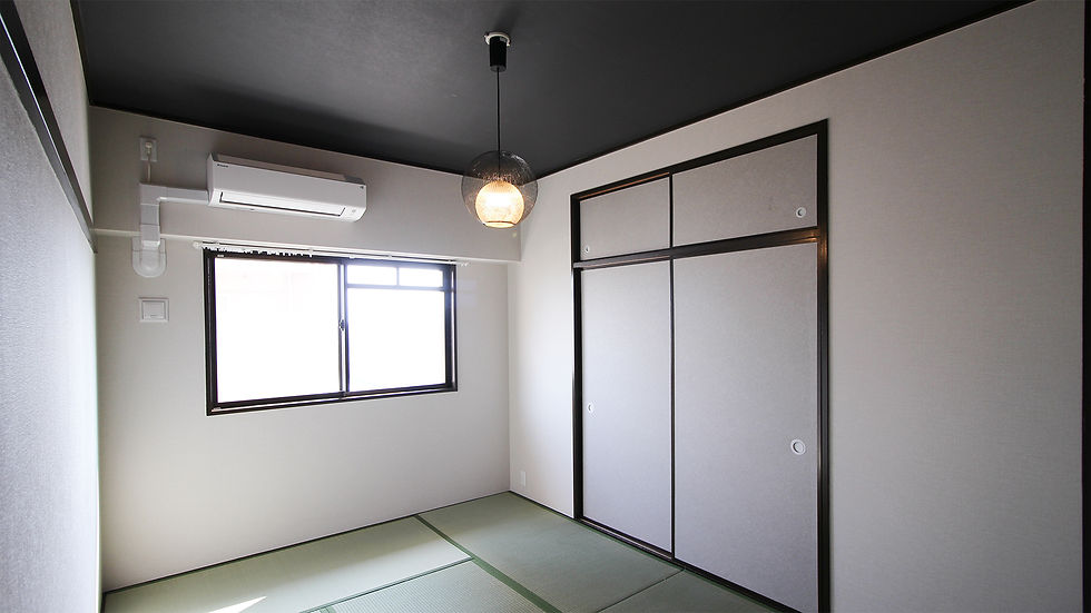 リノベーション後の和モダンな室内。天井を黒く、襖の縁を濃いブラウンで塗装し、洗練された球体照明を配したスタイリッシュな空間