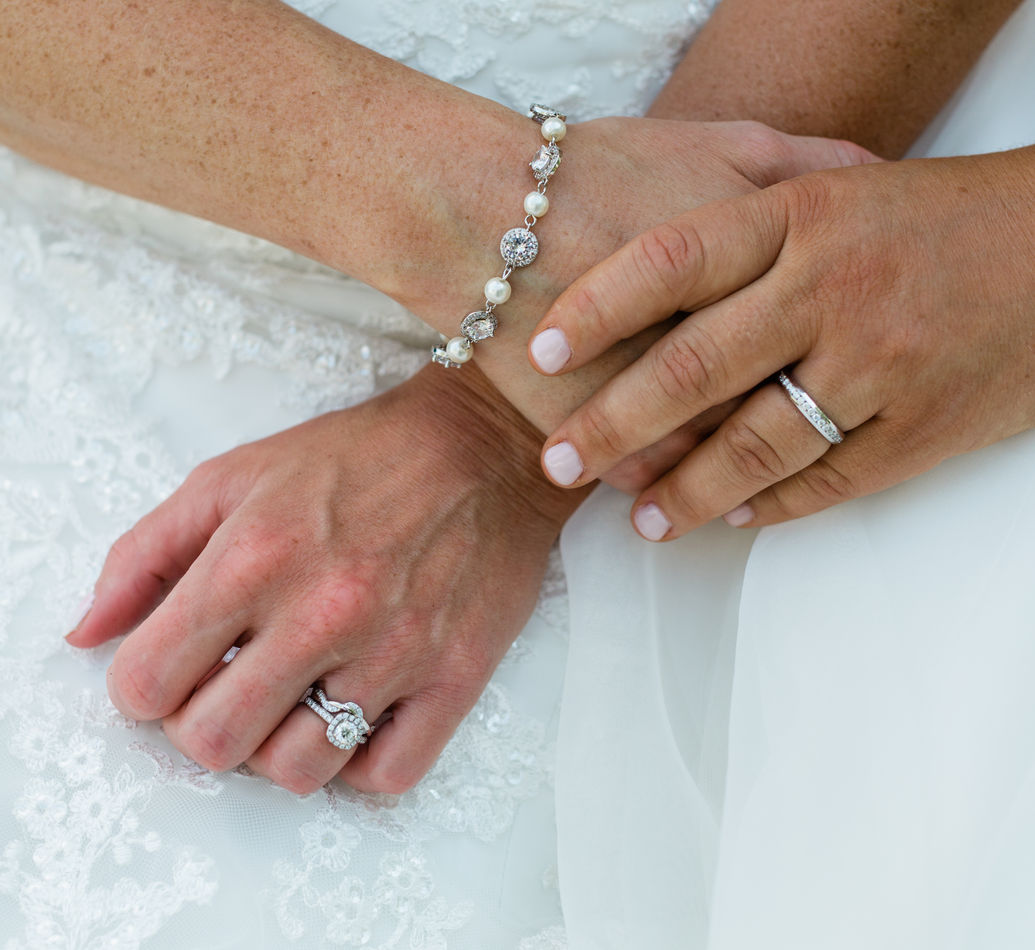 Close up of two brides holding hands