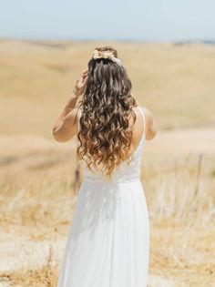 כלה עם שיער גלי בשדה פתוח