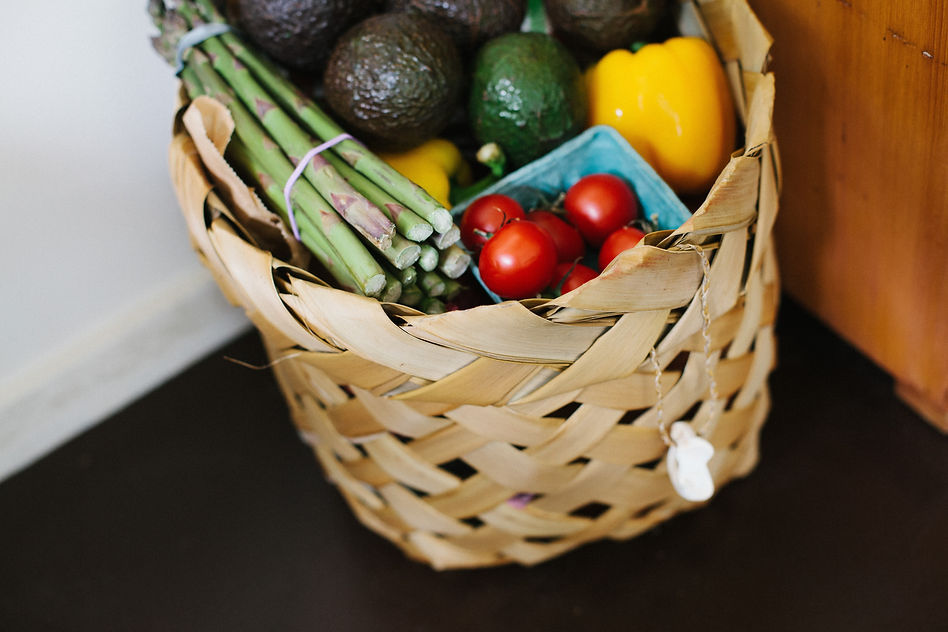 A wicker basket overflowing with a colorful variety of fresh fruits and vegetables