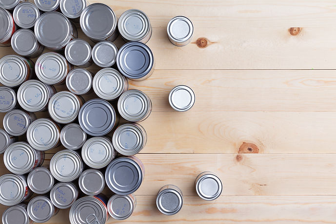 Multiple canned goods organized on a wooden surface.