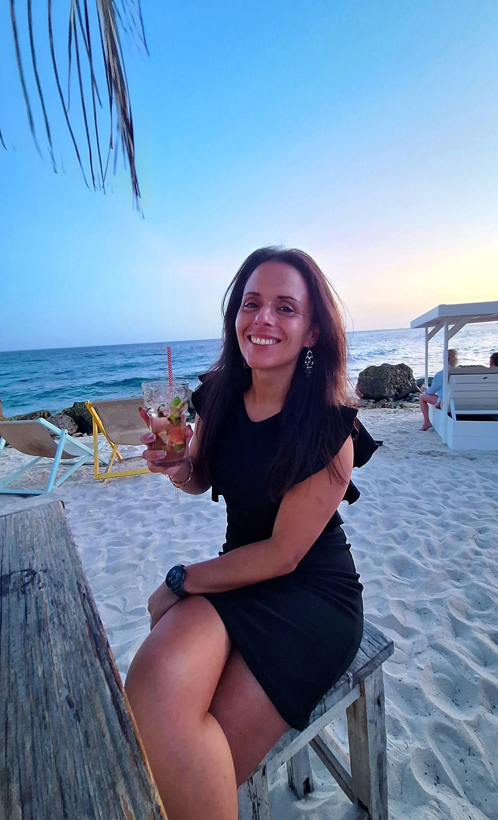 Vrouw geniet van een drankje op het strand