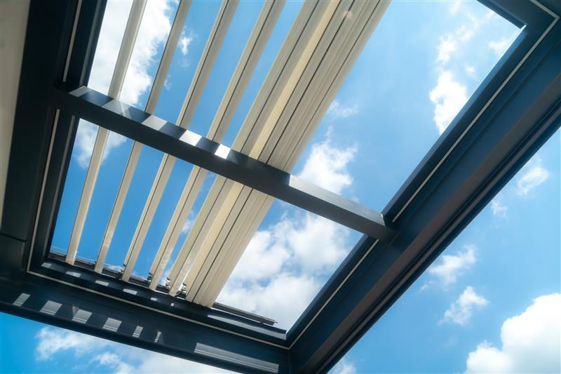 Louvered roof system shading opened to let in the breeze on a hot sunny day