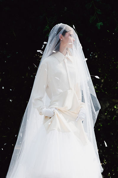Femme en robe de mariée posant avec un air mystérieux lors d'un shooting pour son book de mannequin