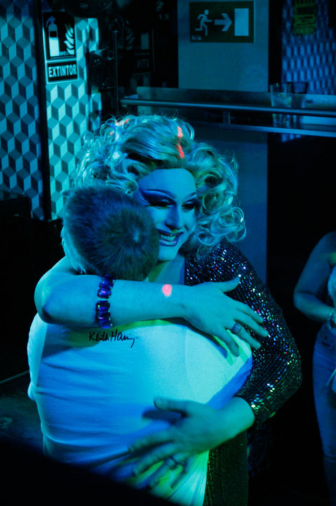 Miss Mars sonriente durante su actuación, abraza cariñosamente a un cliente de LL Bar