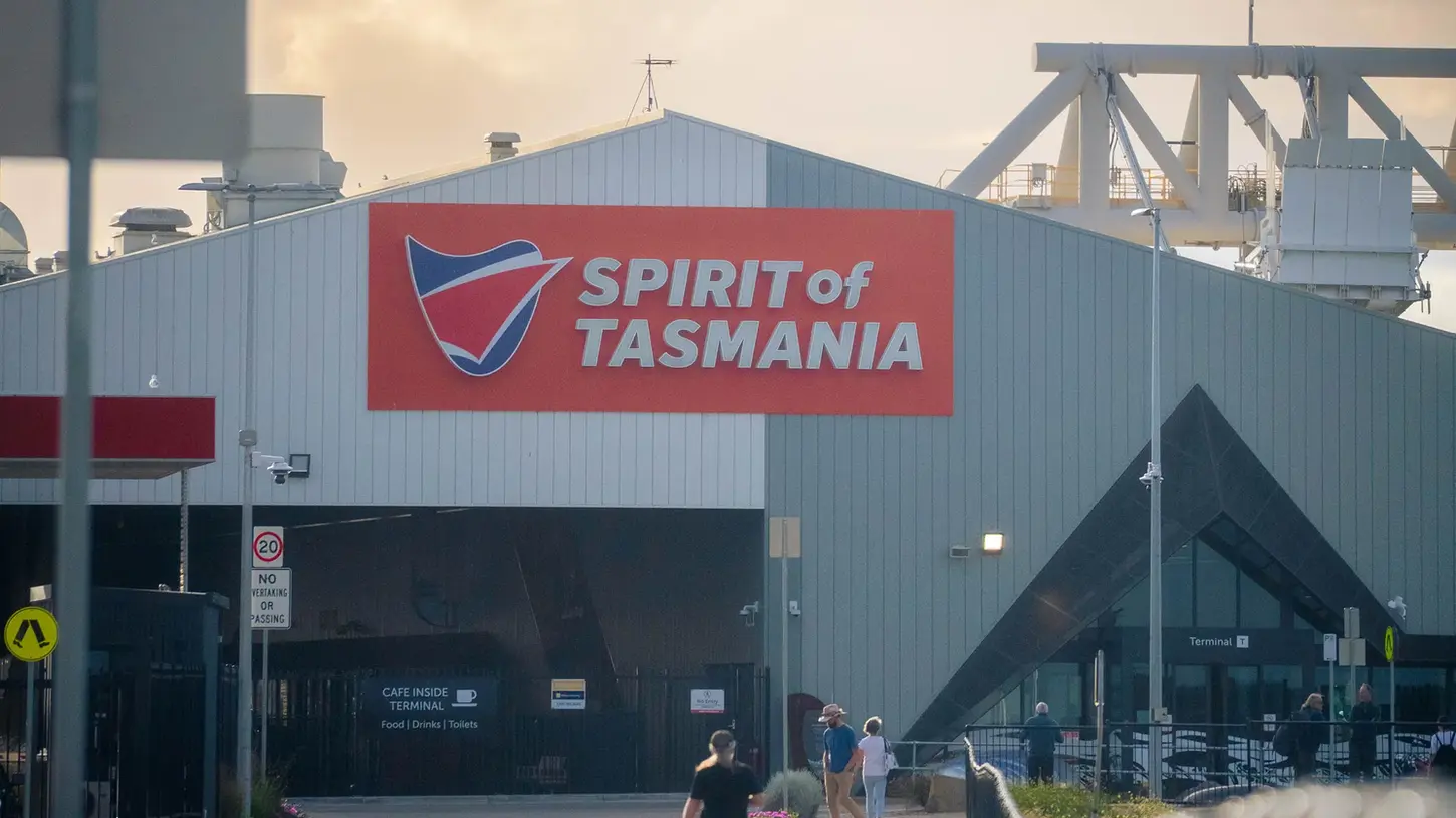 Spirit of Tasmania ferry terminal building at Geelong with passengers walking toward the entrance at sunset