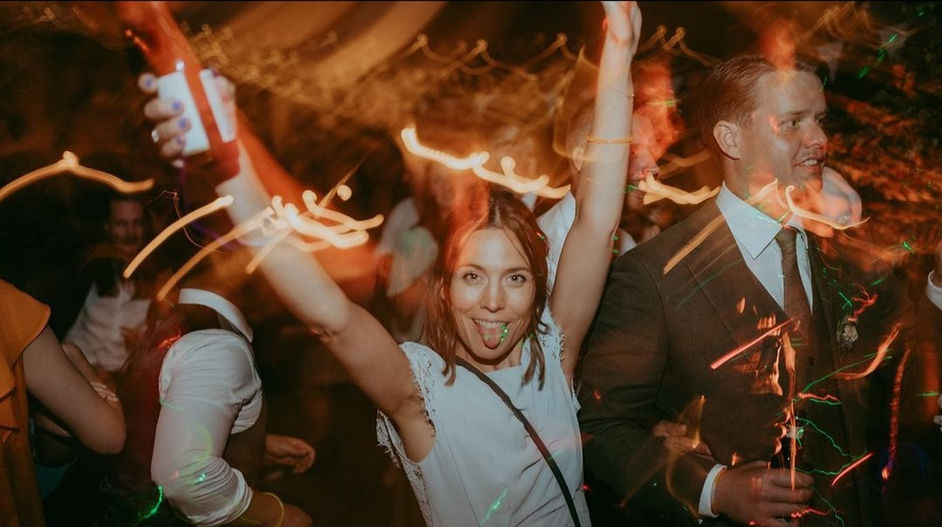 Wedding party cheering and dancing under uplighting at Gloucestershire venue
