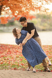 engaged couple swaying and looking at each other in front of fall foliage by the fox river