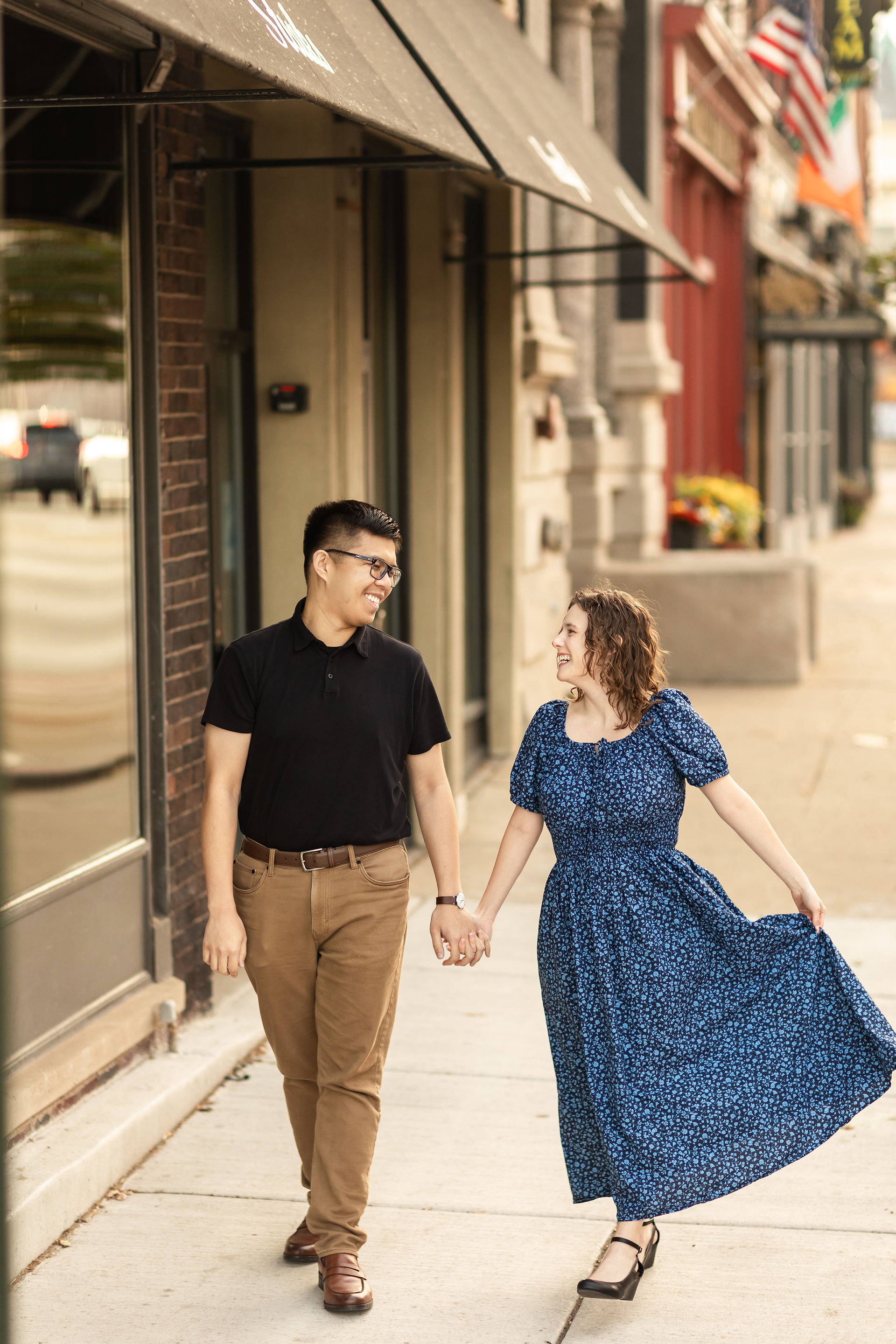 Couple walking along sidewalk in front of shops in downtown St. Charles IL