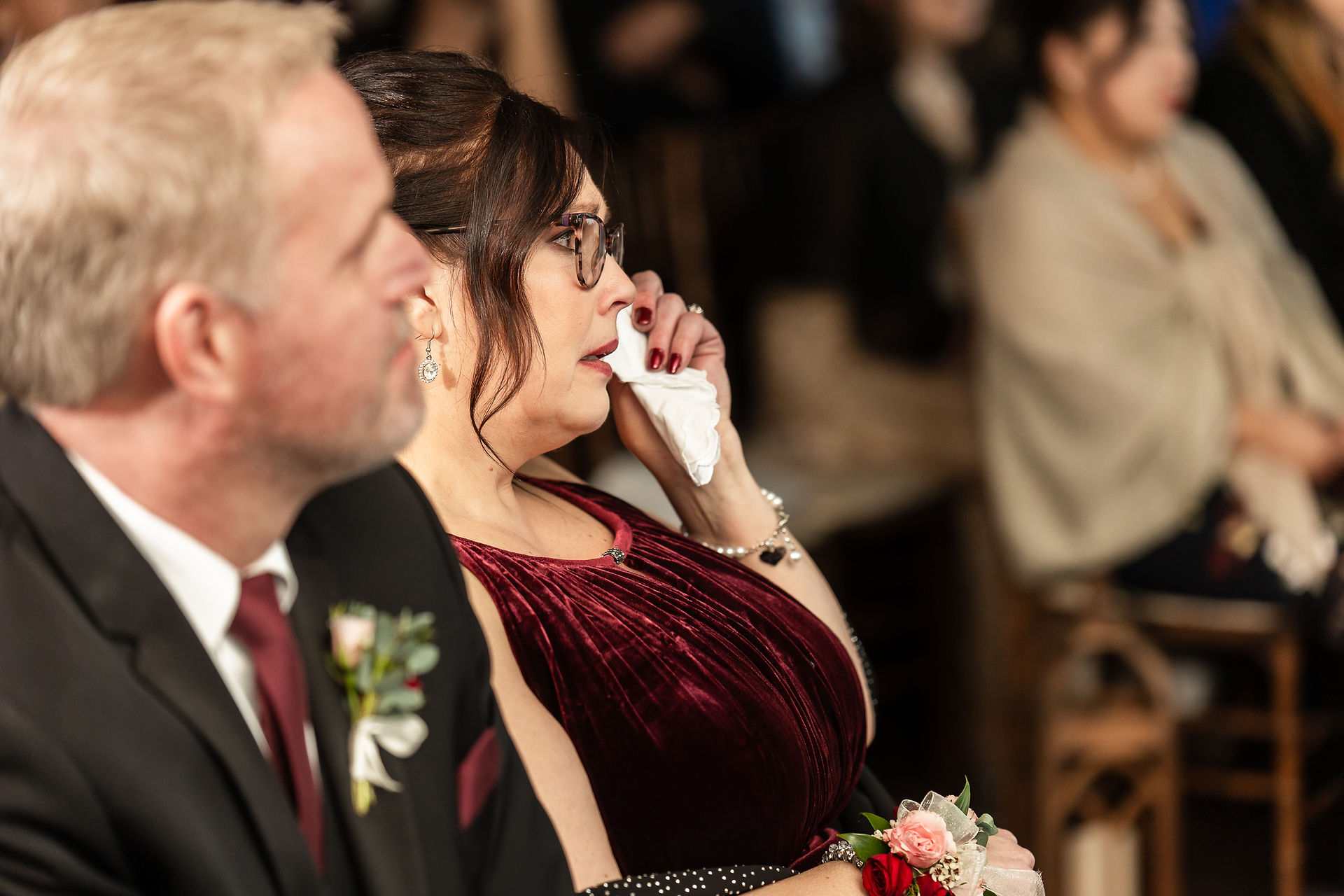 mother of bride wiping away tear during wedding ceremony
