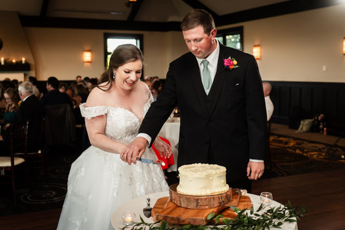 Bride and groom cutting cake served on wood palate 