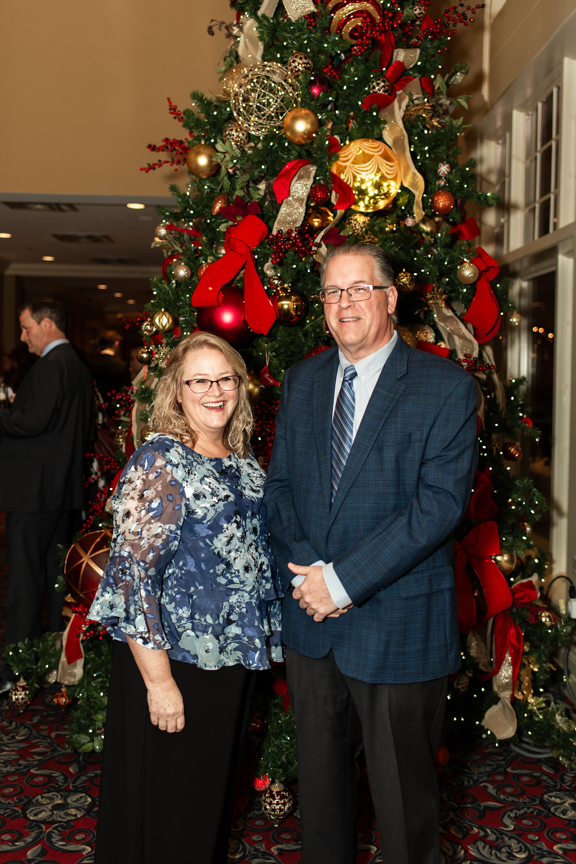 couple standing in front of a christmas tree during cocktail hour