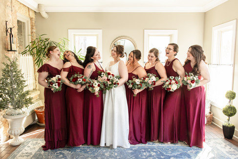 brides and bridesmaids laughing in sunlit vintage room