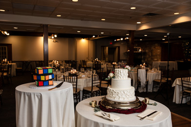 wedding cake with rubik cube cake in dimly lit wedding reception