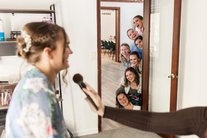 Fun wedding photo with bridesmaids looking around the corner