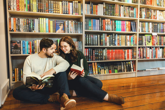 Couple cuddled up reading in a book store