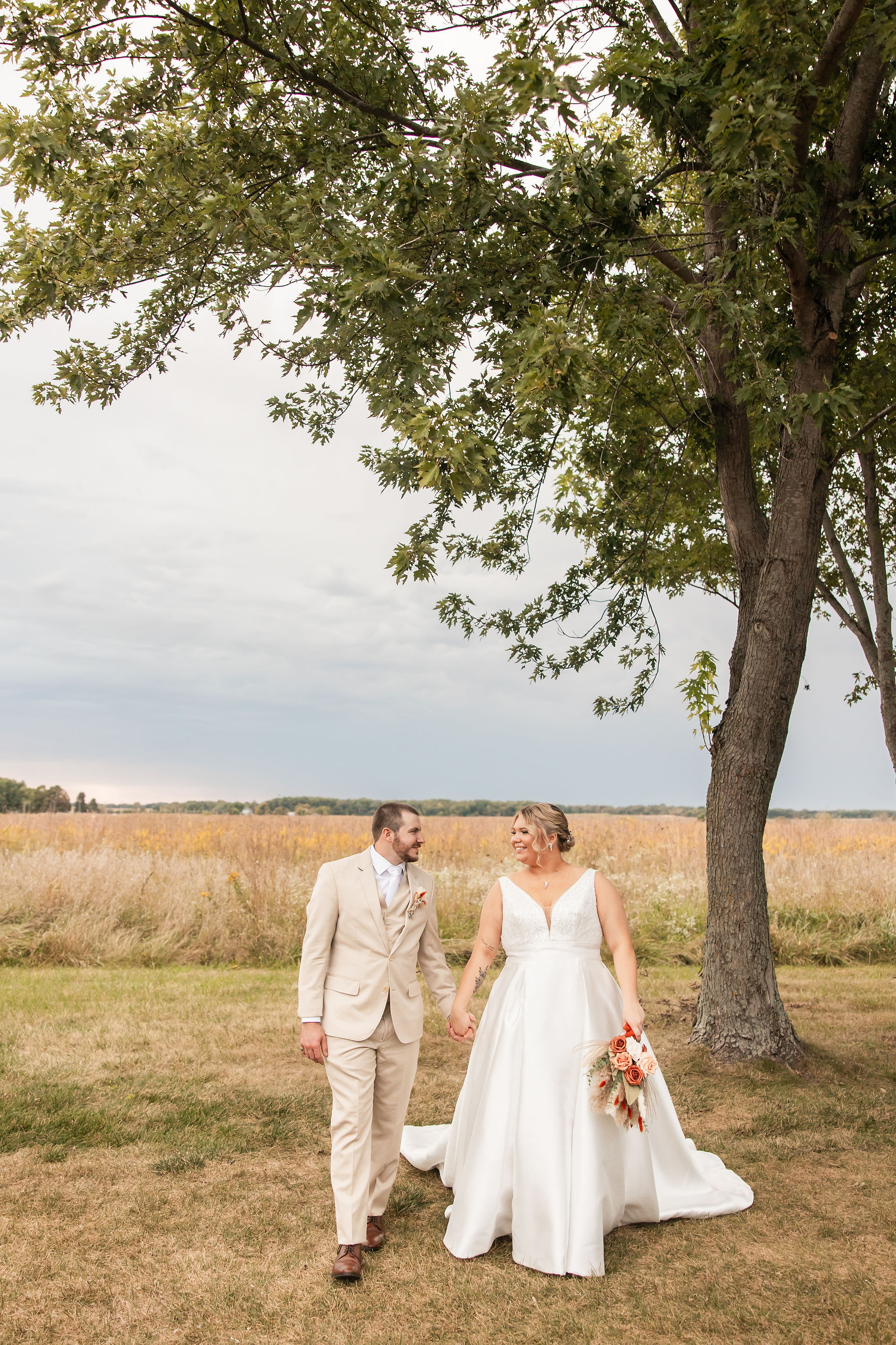 Bride and groom holding hands walking towards the camera