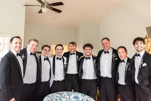 groomsmen casually hanging out while smiling at the camera