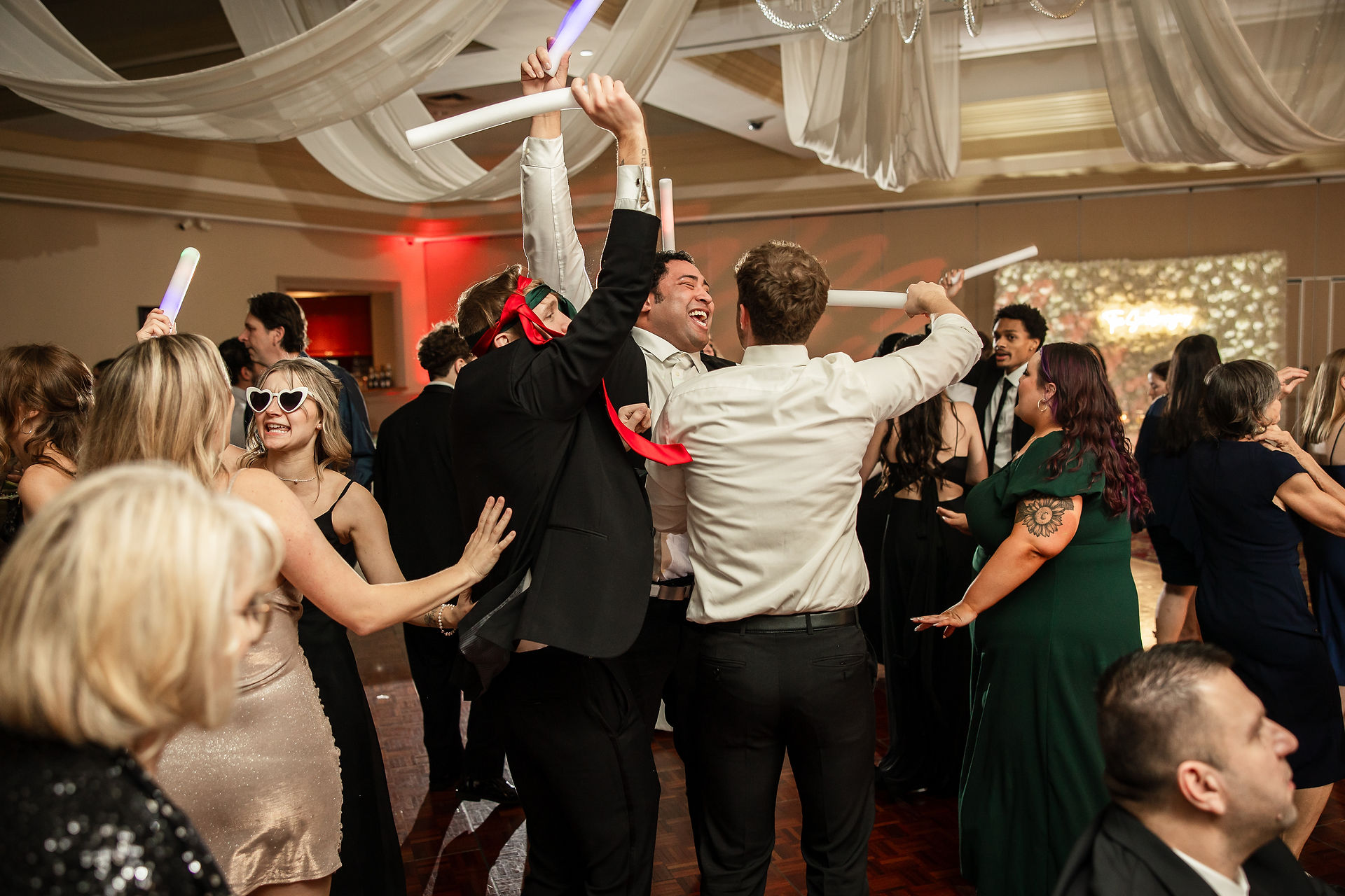 people cheering with light up wands on wedding dance floor
