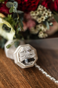 wedding rings in focus with blurry bouquet in background