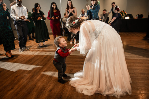 toddler and bride holding hands in the middle of dance floor