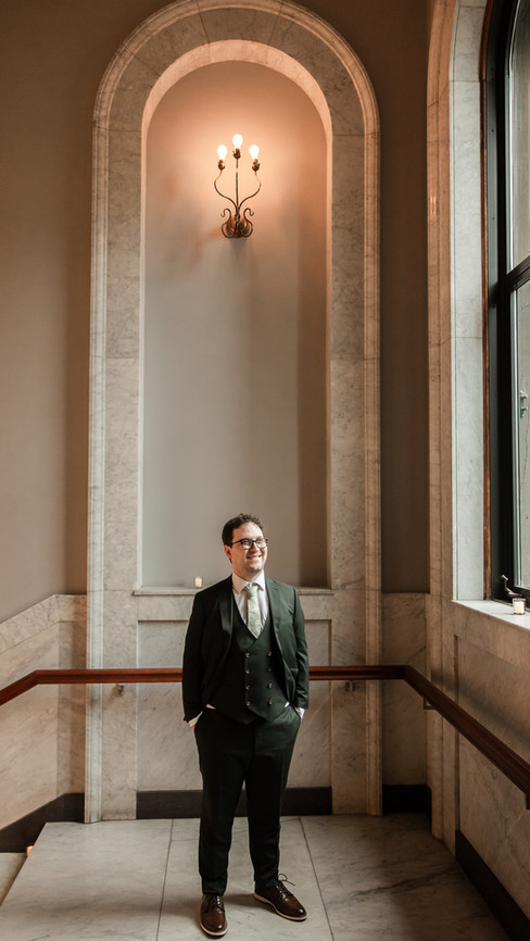 Groom standing under large archway at Newberry Library