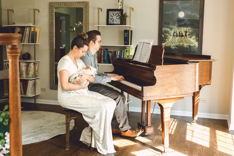 Creative at home newborn session taking place at a piano
