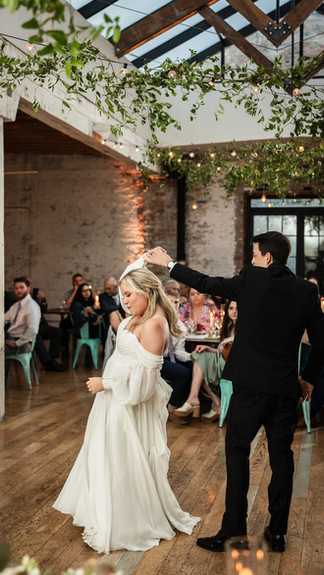 Groom twirls bride during their first dance