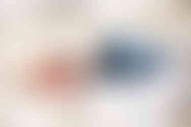 newborn baby sleeping on bed with blue onesie and white blanket