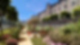 Landscaped urban park with path, people, and historic building