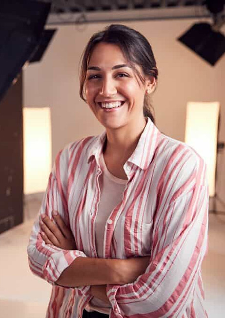portrait-of-smiling-female-photographer-standing-in-studio-with-lighting-equipment-1024x68