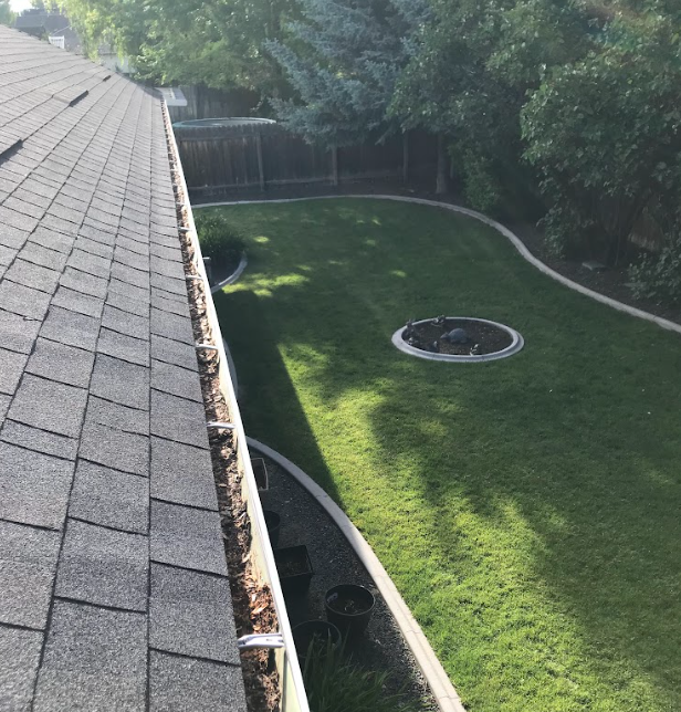 Clogged residential gutters filled with debris before professional gutter cleaning in Boise by Sudz Window and Gutter Cleaning.