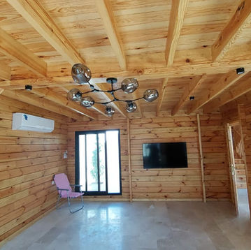 Wooden cabin interior: ceiling, chandelier, TV, and chair