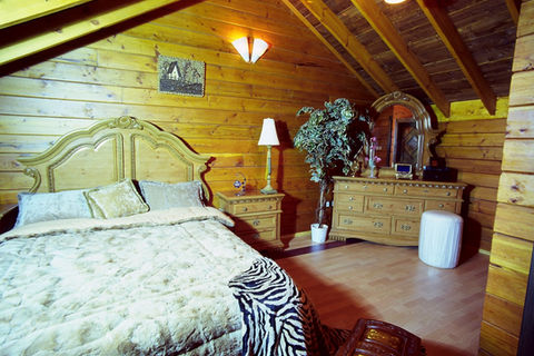 Elegant wooden cabin bedroom with cozy bed