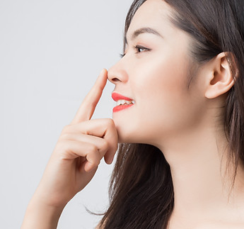 Young beautiful Asian woman with smiley face and red lips touching her nose..jpg