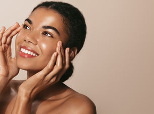 Young african american girl with clear, glowing facial skin, washes her face with cosmetic