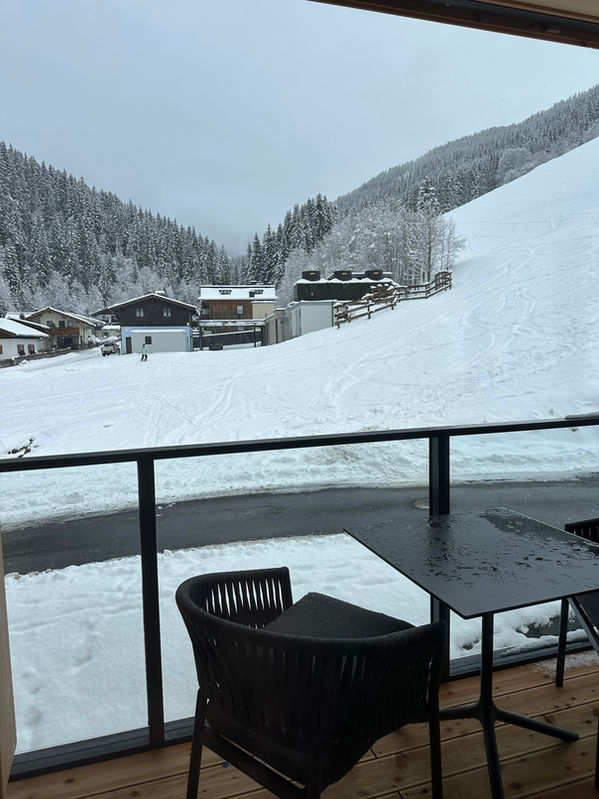 Süd Balkon mit Sitzgelegenheit und Blick auf die Piste und Berge in Premium Spa Suite Saalbach Hinterglemm - Saalbach Suites by Alps Resorts