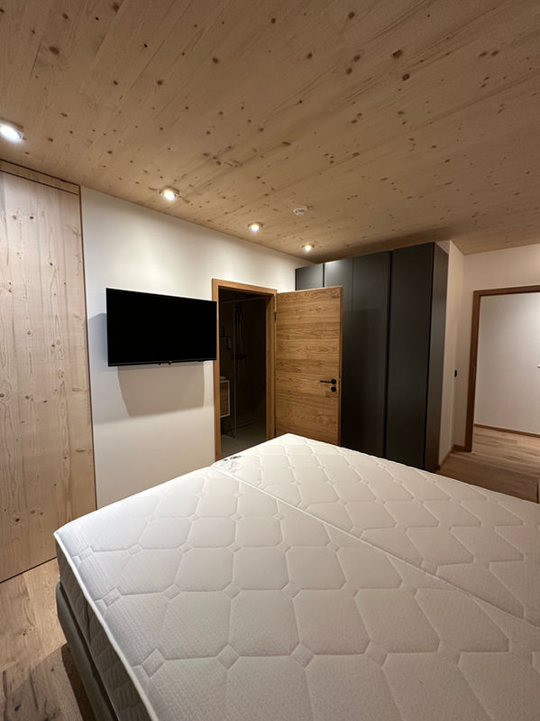 Moosgrünes Schlafzimmer mit TV und EnSuite Bad in Premium Spa Suite Saalbach Hinterglemm - Saalbach Suites by Alps Resorts
