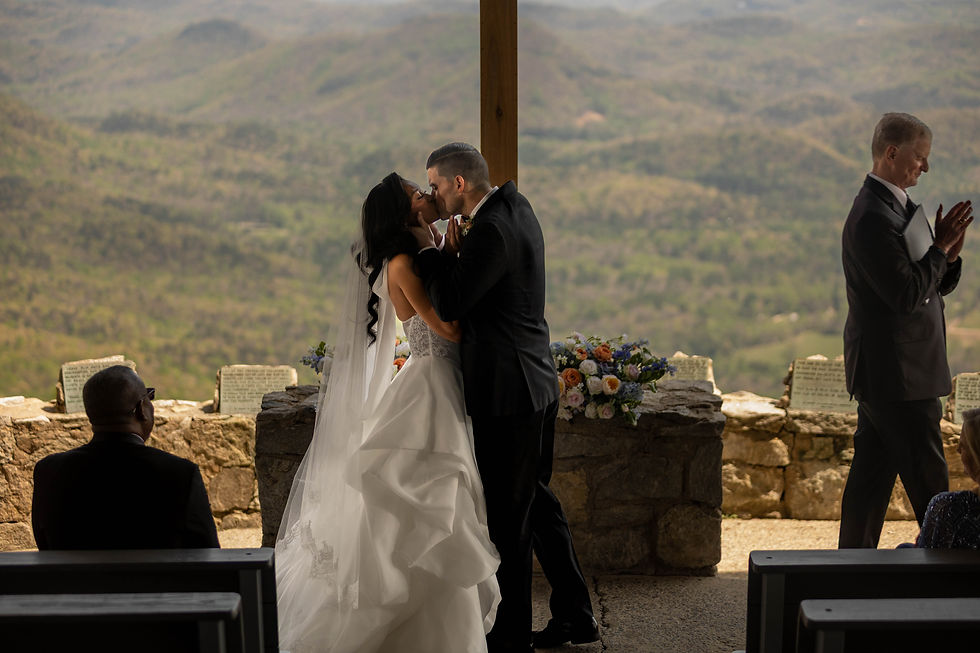 Bride and groom kissing during their Pretty Place Chapel wedding ceremony with mountain views in the background