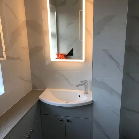Bathroom interior with sink, mirror, and cabinet; One Call Bathroom Solutions.
