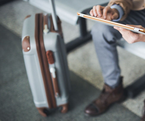 Mann mit Koffer und Tablet