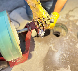 Plumbers using a drain cleaning machine