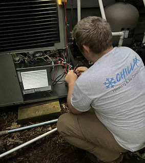 Photo of Steven troubleshooting a wiring issue on a heat pump