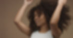 mixed-race-black-woman-portrait-with-big-afro-hair-curly-hair-beige-background-dancing-clo