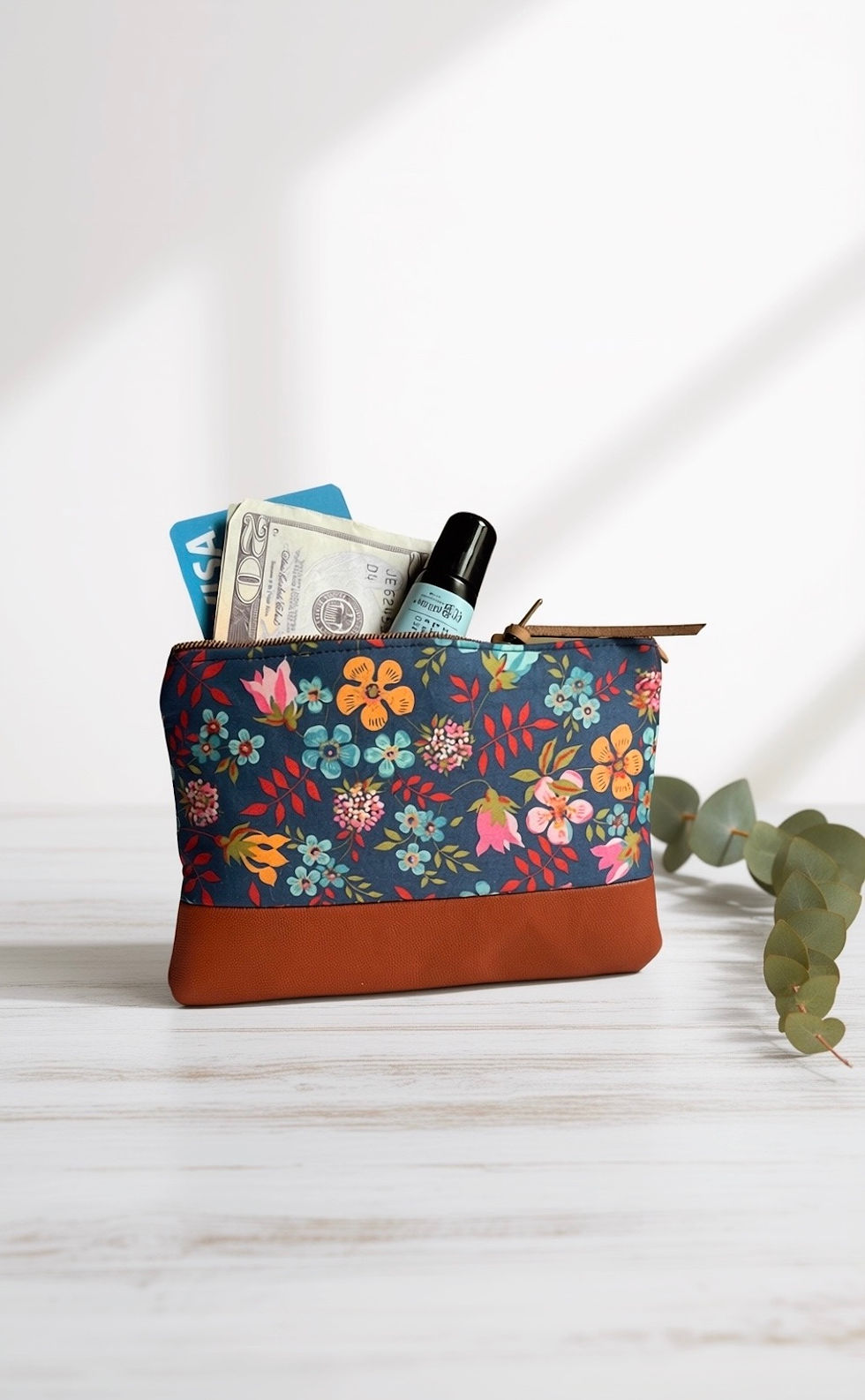 blue ditsy floral zipper coin purse with cards, lip balm, and cash on a white table