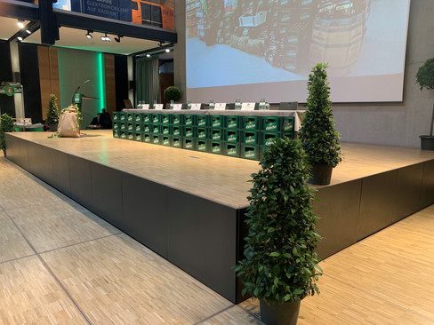 Podium mit Boxen, Pflanzen und Leinwand im PS.SPEICHER