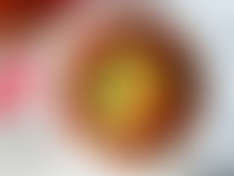 Bowl of hearty OPTAVIA turkey chili topped with avocado, shredded cheese, and scallions