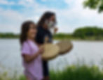 Parent and child drumming in front of water