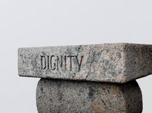 Una statua rudimentale raffigurante la parola "dignità" in lingua inglese (dignity).